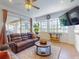 Well-lit living room featuring comfortable leather sofas and large windows overlooking the backyard at 3728 Hunters Isle Dr, Orlando, FL 32837