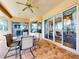 Covered outdoor patio with seating overlooking a pool and lake with sliding glass doors to the interior at 3728 Hunters Isle Dr, Orlando, FL 32837