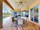 Comfortable outdoor dining area with tile flooring and screened enclosure offers a serene view of the pool and lake at 3728 Hunters Isle Dr, Orlando, FL 32837
