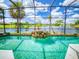 Lush landscaped pool with rock waterfall and lake view through screened enclosure for serene outdoor living at 3728 Hunters Isle Dr, Orlando, FL 32837