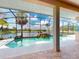Screened-in pool with waterfall feature and scenic lake view, perfect for relaxation and outdoor enjoyment at 3728 Hunters Isle Dr, Orlando, FL 32837