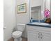 Cozy half-bathroom with blue vanity, decorative mirror, and floral accents at 404 Bar Ct, Kissimmee, FL 34759