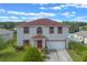 Charming two-story home features red trim, a well-manicured lawn, and an attached two-car garage at 404 Bar Ct, Kissimmee, FL 34759