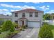 Charming two-story home features red trim, a well-manicured lawn, and an attached two-car garage at 404 Bar Ct, Kissimmee, FL 34759