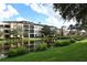 Exterior view of the community buildings overlooking a pond with manicured lawns and mature trees at 506 Mirasol Cir # 202, Celebration, FL 34747