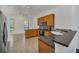 Spacious kitchen featuring tile floors, wood cabinets, stainless steel appliances, and dark countertops at 506 Mirasol Cir # 202, Celebration, FL 34747