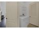 Bright laundry room features a white washer and dryer set, wire rack shelving and interior door at 506 Mirasol Cir # 202, Celebration, FL 34747