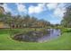 Scenic view of a pond surrounded by lush greenery and a residential community on the opposite bank at 506 Mirasol Cir # 202, Celebration, FL 34747