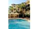 Resort style pool with lounge chairs and covered sitting area, surrounded by mature palm trees at 506 Mirasol Cir # 202, Celebration, FL 34747