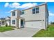 Charming two-story home featuring a two-car garage, blue door, and well-maintained landscaping at 5135 Marshelder St, Apopka, FL 32712