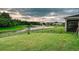 Backyard view of a lush green lawn with a fence and a serene pond featuring a fountain and neighboring houses at 5169 Dove Tree, Orlando, FL 32811