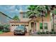 Stunning two-story home with a brick driveway, lush landscaping, and mature palm trees, giving it great curb appeal at 5169 Dove Tree, Orlando, FL 32811