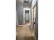 A well-lit hallway with neutral-colored walls, doors on either side, and stylish flooring at 5169 Dove Tree, Orlando, FL 32811