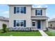 Charming two-story home featuring blue shutters, stone accents, and a well-manicured lawn at 5242 Scrub Mint Ln, Apopka, FL 32712