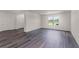 Bright living room featuring wood-look floors, white walls, and a window providing natural light at 5242 Scrub Mint Ln, Apopka, FL 32712