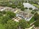 Aerial view of blue townhomes nestled among lush green trees and serene pond with fountain at 6027 Strada Isle Way, Orlando, FL 32835