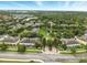 An aerial view capturing community townhomes surrounding a small pond and mature trees at 6027 Strada Isle Way, Orlando, FL 32835