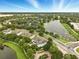 An aerial view showcasing a community surrounding a serene pond with fountain and lush green trees at 6027 Strada Isle Way, Orlando, FL 32835