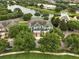 Aerial view capturing blue townhomes surrounded by lush trees and a scenic pond with connecting bridge at 6027 Strada Isle Way, Orlando, FL 32835