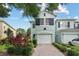 Inviting two-story townhome with a brick driveway, attached garage, and lush landscaping at 6027 Strada Isle Way, Orlando, FL 32835