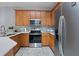 Well-equipped kitchen featuring stainless steel appliances, natural wood cabinets, and tile backsplash at 6027 Strada Isle Way, Orlando, FL 32835