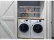 Convenient laundry room with stacked washer and dryer and built-in shelving at 6027 Strada Isle Way, Orlando, FL 32835