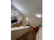 View from stairs of a living room showcasing the vaulted ceiling, TV, and comfortable furnishings at 6328 Raleigh St # 814, Orlando, FL 32835
