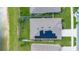Aerial view of home with solar panels on roof, set on a lot by the lake at 633 Greymount St, Davenport, FL 33837