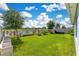 Large backyard with lush green grass, fire pit, and a scenic view of the pond at 633 Greymount St, Davenport, FL 33837