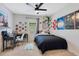 This cozy bedroom includes a ceiling fan, a workspace with modern chair, and fun decorations throughout at 633 Greymount St, Davenport, FL 33837