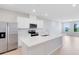 Modern kitchen featuring white cabinetry, stainless steel appliances, and a spacious island with quartz countertop at 6331 Breeze Filled Ln, Winter Garden, FL 34787