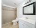 Bathroom featuring a tiled shower, white vanity, and a square mirror with a black frame at 645 Stafford Ter # 163, Altamonte Springs, FL 32714
