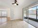 Open bedroom with tile flooring, ceiling fan and screened patio access overlooking parking area at 645 Stafford Ter # 163, Altamonte Springs, FL 32714