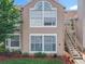 Close-up of a townhouse exterior with a staircase leading to a second-story entrance and large windows at 645 Stafford Ter # 163, Altamonte Springs, FL 32714