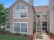 Townhome exterior with a stairway leading to an upper-level entryway, large windows, and green lawn at 645 Stafford Ter # 163, Altamonte Springs, FL 32714