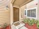 Townhome front door with a well-lit entryway, a welcoming doormat, and neat landscaping at 645 Stafford Ter # 163, Altamonte Springs, FL 32714