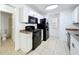 Clean kitchen featuring white cabinetry, neutral countertops, and matching black appliances at 645 Stafford Ter # 163, Altamonte Springs, FL 32714