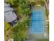 Aerial view of community tennis court next to condominiums surrounded by mature trees and landscaping at 645 Stafford Ter # 163, Altamonte Springs, FL 32714