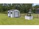 View of backyard shed, wishing well and playground set, all surrounded by green lawn and trees at 7191 Old Melbourne Hwy, St Cloud, FL 34771