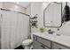 Well-lit bathroom features a shower with a patterned curtain and a modern vanity at 7191 Old Melbourne Hwy, St Cloud, FL 34771