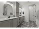Elegant bathroom featuring a gray vanity with dual sinks and decorative tile flooring at 7191 Old Melbourne Hwy, St Cloud, FL 34771