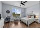 Bright bedroom with a ceiling fan, hardwood floors, rocking chair, and a window with a view at 7191 Old Melbourne Hwy, St Cloud, FL 34771