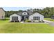 Charming single-story farmhouse with green lawn, blue door, black shutters and manicured landscaping at 7191 Old Melbourne Hwy, St Cloud, FL 34771