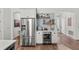 Kitchen with stainless steel refrigerator, wine cooler, white cabinets, and stylish decor on floating shelves at 7191 Old Melbourne Hwy, St Cloud, FL 34771