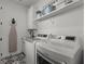 Laundry room features modern appliances, farmhouse decor and patterned floor tiles at 7191 Old Melbourne Hwy, St Cloud, FL 34771