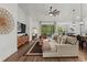 Bright living room with hardwood floors, comfortable seating, and large windows offering backyard views at 7191 Old Melbourne Hwy, St Cloud, FL 34771
