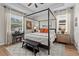 Stylish main bedroom boasts a canopy bed, tray ceiling, and a sitting area at 7191 Old Melbourne Hwy, St Cloud, FL 34771