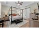 Elegant primary bedroom featuring a four-poster bed, modern decor, and a sliding barn door at 7191 Old Melbourne Hwy, St Cloud, FL 34771