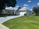 Well-manicured lawn with charming single-story home featuring a spacious two-car garage at 732 Palma Dr, Lady Lake, FL 32159
