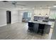 Bright, open kitchen features a large island with marble countertop, stainless steel appliances, and gray vinyl plank flooring at 732 Palma Dr, Lady Lake, FL 32159